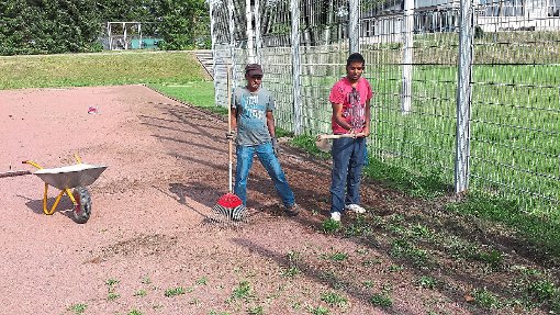 Im Einsatz:  Thirunavakasaru (links) und  Suthrsan Manickavasar  bei ihren Arbeiten auf dem Tuninger Sportgelände. Foto: Bieberstein Foto: Schwarzwälder-Bote