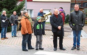 Bei der Eröffnung des Alpirsbacher Weihnachtsmarkts: Maria Klink (vorne links), Bürgermeister Reiner Ullrich (vorne, Zweiter von rechts) und HGV-Vorsitzender Georg Steinberger (rechts) vor den Alpirsbacher Musikfreunden Foto: Hering