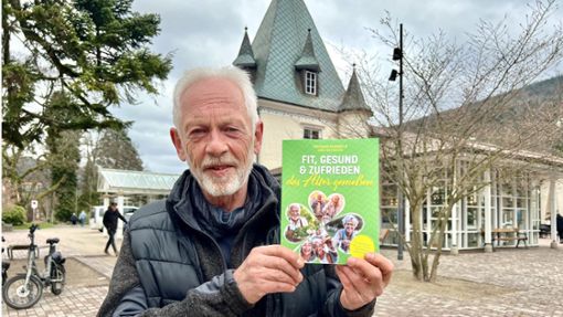 Wolfgang Scheiber mit seinem seinen neuen Ratgeber „Fit, gesund und zufrieden das Alter genießen“ vor dem Kurhaus in Bad Herrenalb. Foto: Zoller