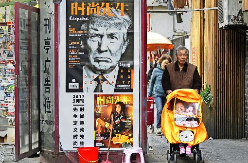 An einem Zeitungsladen in Shanghai hängt ein Werbeplakat für eine Zeitschrift – deren Titelblatt die finstere Miene Trumps zeigt. Foto: AP
