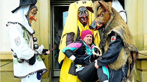 Ortsvorsteher Rüdiger Holderried wird von den Bildechinger Narren aus dem Rathaus getragen. Foto: Peter Morlok