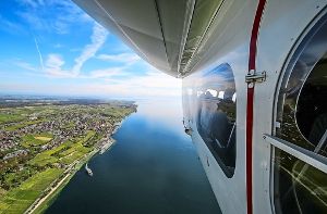 Perspektivwechsel: Aus dem geöffneten Fenster des Zeppelins lässt sich die Bodenseeregion neu entdecken  – wie hier das Ufer bei Meersburg. Foto: Michael Haefner