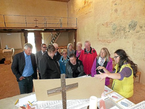 Stefanie Doldinger (rechts) erklärt den Besuchern der Alten Michaelskirche in Burgfelden, was auf den rund 1000 Jahre alten Fresken des Gotteshauses zu erahnen ist. Foto: Kistner Foto: Schwarzwälder-Bote