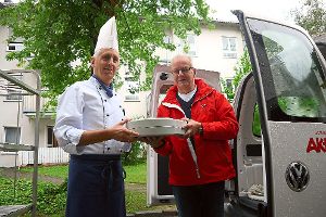 Koch Hans-Peter Fritsch übergibt das Essen dem Fahrer Helmut Wöhrle.  Foto: Kornfeld