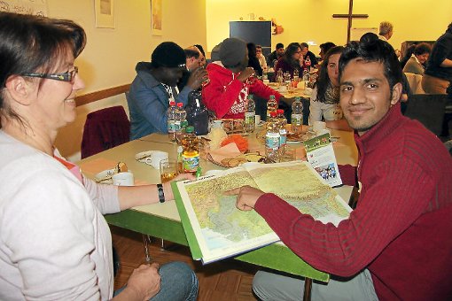 Austausch in lockerer Atmosphäre: Beim Asyl-Café im Gemeindehaus Conweiler können sich Bürger und Asylbewerber kennenlernen. Der junge Pakistaner Awan Abu Sufyan zeigt Jutta Bürkle-Hautsch im Atlas, wo er herkommt. Foto: Schwarzwälder-Bote