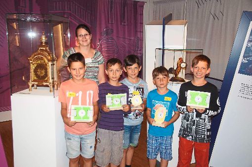 Stolz zeigen die Kinder mit Volontärin Claire Hölig die Wecker, die sie im Uhrenmuseum gebastelt haben.   Foto: Heimpel Foto: Schwarzwälder-Bote