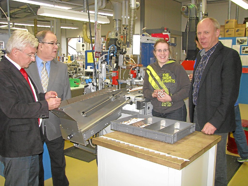 Geschäftsführer Lutz Heubach (von links) sowie Lebenshilfe-Vorsitzender Helmut Pfotzer und Manfred Schmid besuchen Ramona Schmieder an ihrem Arbeitsplatz in der Siebdruckerei.