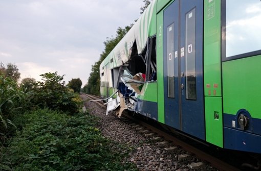 Ein aufgerissenrer Waggon eines Zuges steht Montag an einem unbeschrankten Bahnübergang bei Ihringen. Dort waren ein Zug und ein Lastwagen kollidiert. Weitere Bilder des Unfalls sehen Sie in unserer Fotostrecke. Foto: dpa