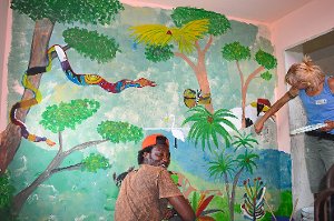 Faoumar Dibbasey aus Gambia malt mit einer  Kunstdozentin der Jugendkunstschule am Dschungel-Bild. Fotos: Cools Foto: Schwarzwälder-Bote