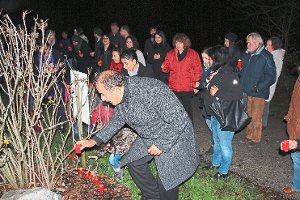 Die Teilnehmer des Treffens zum Internationalen Tag gegen Gewalt an Frauen legten am Denkmal gegen sexuelle Gewalt am Norduferweg Kerzen nieder.  Foto: Feinler Foto: Schwarzwälder-Bote