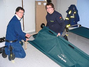Lars Hornung (links) und Michael Grode vom Technischen Hilfswerk (THW) aus Donaueschingen bauen Feldbetten für Flüchtlinge auf.  Foto: Klausner Foto: Schwarzwälder-Bote