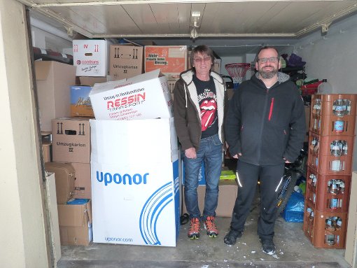 Bei Lothar Rees und Tobias Raff (von links) türmen sich in der Garage   die vielen Kleiderspenden.  Foto: Klossek Foto: Schwarzwälder-Bote