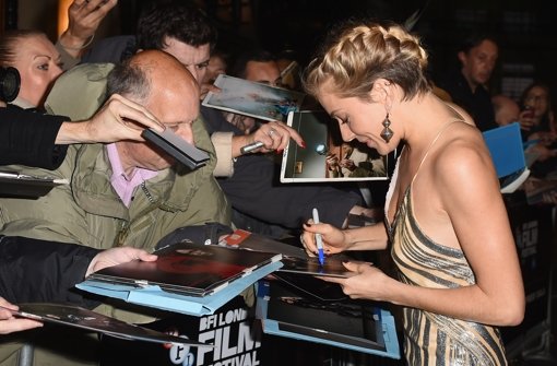 Sienna Miller schreibt bei der Premiere von Foxcatcher in London eiftig Autogramme. Foto: Getty Images Europe