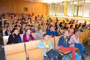 Die Teilnehmer der Kinder-Uni lauschen gespannt, was Dozent Markus Egert über Mikroorganismen erzählt (links). In den Workshops ist dann Eigeneinsatz gefragt. Beispielsweise beim Löten, dem Aufweichen von Gelatine oder beim Scannen von Codes. Foto: Schwarzwälder-Bote