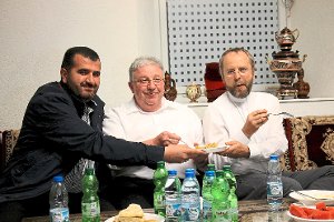 Imam Metin Sunnetci reicht den Pfarrern Andreas Treuer und Markus Ockert (von links) eine Süßspeise, die beiden ganz offensichtlich schmeckt. Foto: Kommert Foto: Schwarzwälder-Bote