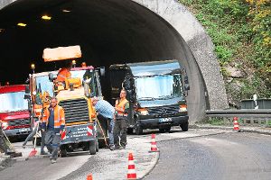 Nicht ganz einfach haben es die Mitarbeiter der Firma Karl Müller aus Niedereschach, die die Fahrbahndecke am Zuckerhut-Tunnel reparieren – umgeben vom fließenden Verkehr. Foto: Kommert Foto: Schwarzwälder-Bote