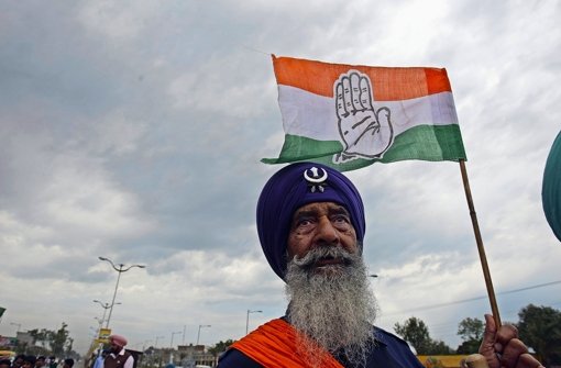 Mammutwahl in Indien: Ein Sikh hält die Flagge der regierenden Kongresspartei empor Foto: dpa