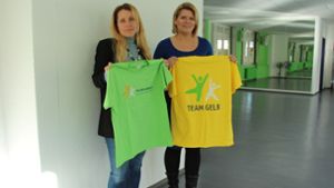 Zum Team Gelb und Team Grün kommt neu das Team Blau. Nadine Breisch (links) und Fachbereichsleiterin Dagmar Hirschpek freuen sich über die nagelneuen Shirts. Foto: Thiercy
