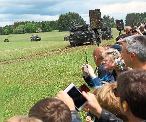 Handys und Kameras im Anschlag: Groß ist das Interesse, als die Panzer anrücken.  Foto: Grimm