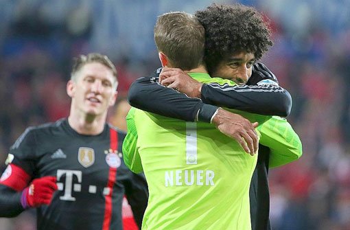 Nach dem Abpfiff liegen sich der Münchener Torwart Manuel Neuer (vorne) und Dante in den Armen. Bayern hat die Hinrunde mit 2:1 gegen Mainz beendet. Foto: dpa