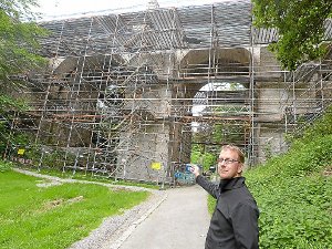 Björn Claussen zeigt auf die Baustelle an der Hochbrücke, an der ein Fangnetz zur Suizidprävention angebracht werden soll. Foto:  Maier