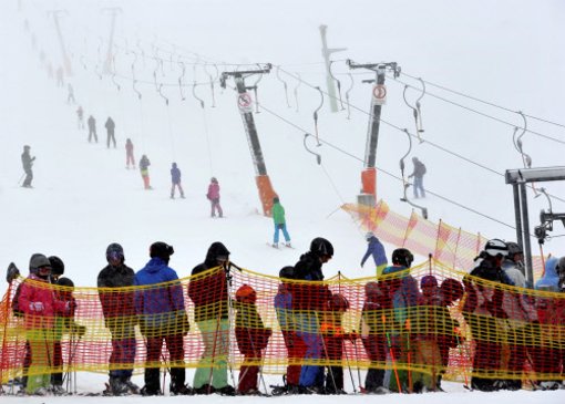 Am Feldberg ist mächtig was los: Skifahrer warten an einem Skilift.  Foto: dpa