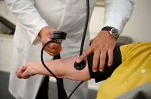 Ein Stuttgarter Hausarzt misst in seiner Praxis einer Patientin den Blutdruck. Foto: dpa/Bernd Weißbrod