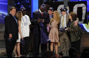 Michael Oher (Mitte, mit Trikot) mit der Familie Tuohy (in Rosé: Leigh Anne) bei seinem Draft durch die Baltimore Ravens im Jahr 2009. Foto: IMAGO/USA TODAY Network/IMAGO/Howard Smith-USA TODAY Sports