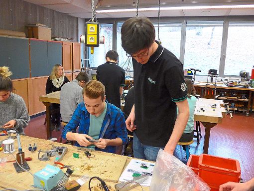 Ein Auszubildender der Firma Arburg gibt Anleitungen beim Bau eines Modellrennwagens.  Foto: Werkrealschule Foto: Schwarzwälder-Bote