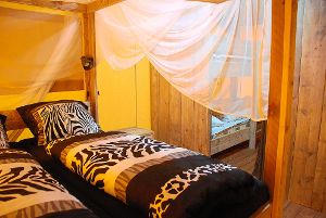 Erwachsene schlafen in Betten mit Zebra-Muster. Die Moskitonetze dürfen nicht fehlen. Foto: Schwarzwälder-Bote