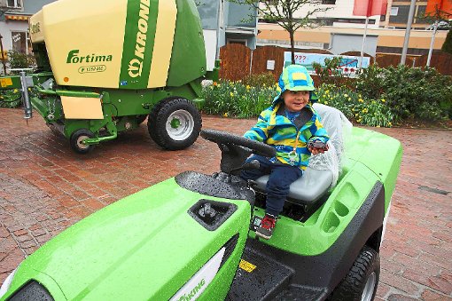 Wenn sich kaum jemand für die großen auf dem Marktplatz ausgestellten Traktoren von Schmied Hug interessiert, der kleine Louis freut sich auf jeden Fall, dass er auch bei Regenwetter auf dem Rasentraktor Platz nehmen kann.  Foto: Heimpel Foto: Schwarzwälder-Bote