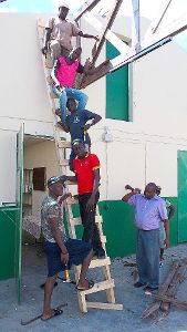 Mit vereinten Kräften wurde  das Dach der Autowerkstatt eines Ausbildungszentrums wieder aufgerichtet.  Fotos: Pro Haiti Foto: Schwarzwälder-Bote