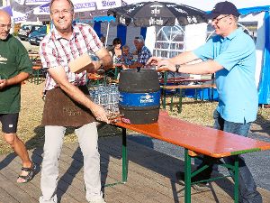 Er kann’s: Ralf Ulbrich sticht das erste Fass des Dorffests an (linkes Bild). Und die durstigen Besucher bekommen Getränke am Neckarrand (rechtes Bild). Foto: Schwarzwälder-Bote