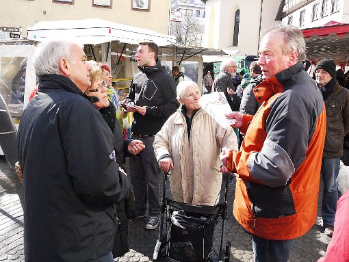 Klaus Konzelmann (rechts) umringt von Bürgern: Viele wollen wissen, warum er mit Verspätung ins Rennen geht. Foto: Eyrich