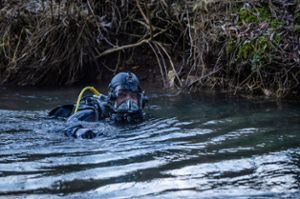 Ein Polizeitaucher sucht das Gewässer der Lauchert nach einem zweijährigen Kind ab, das seit vorgestern vermisst wird.  Foto: Christoph Schmidt/dpa