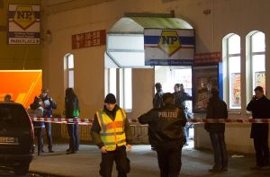 Polizeibeamte stehen in der Tatnacht vor dem überfallenen Supermarkt in Hannover. Foto: dpa