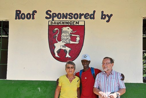 Dieser junge Mann hat das Wappen der Gemeinde in Dauchingen auf das Schulgebäude gemalt und präsentiert es stolz der Familie Reinelt.  Repro: Preuß Foto: Schwarzwälder-Bote
