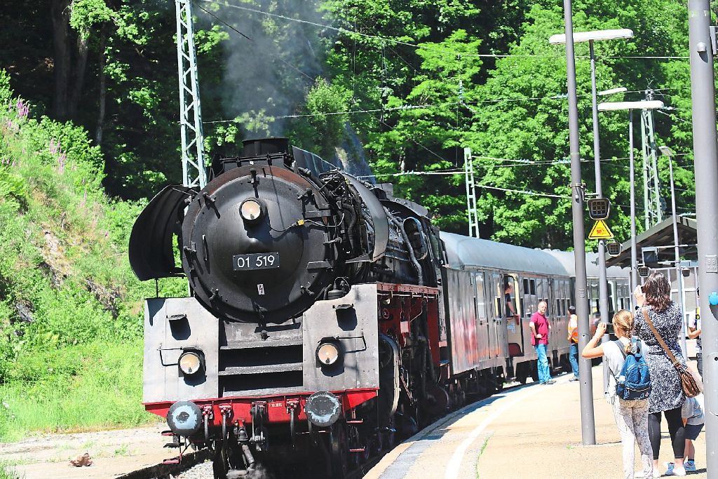 Majestätisch fauchend gleitet der Zug, eingehüllt von einer riesigen Rauch- und Dampffahne aus dem Bahnhof.