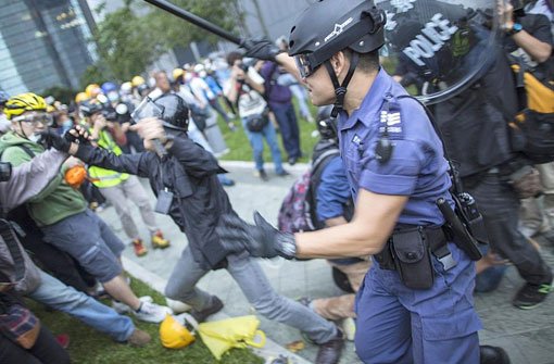 Polizisten räumen eine Straße im Zenrum Hongkongs: Die Proteste prodemokratischer Aktivisten sind neu entflammt.  Foto: dpa