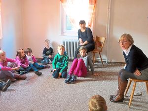 Angelika Pieper (rechts)  erzählt in der Owinger Bücherei spannende Abenteuer von Trollen aus der Bretagne. Die Kinder lauschen andächtig. Auch mit dabei: Die Austauschlehrerin Saule Naurzbaeva aus Kasachstan (hinten).  Foto: OWB Foto: Schwarzwälder-Bote