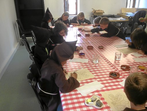 In Mönchskutten gekleidet versuchten sich die Kinder am Schreiben mit dem Gänsekiel. Foto: CVJM Foto: Schwarzwälder-Bote