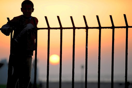 Ein Jugendlicher steht  in einem Flüchtlingslager in Benghasi (Libyen) an einem Zaun und schaut in Richtung der untergehenden Sonne. Trotz der lebensgefährlichen Fahrt über das Mittelmeer wagen viele Tausend Menschen die Flucht nach Europa.  Die Gemeinde Gechingen zeigt sich nun offen für die Aufnahme weiterer Asylbewerber.  Foto: Archiv Foto: Schwarzwälder-Bote