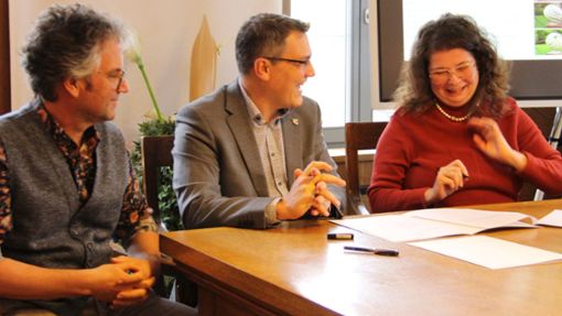 Das Ehepaar Sabine und Erwin Scher mit Oberbürgermeister Dirk Abel (Mitte) bei der Unterzeichnung des Vertrags. Foto: Thiercy
