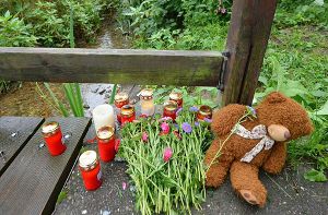 Kerzen, Blumen ud Stofftiere liegen auf einer Brücke an dem Bach in Freiburg, in dem ein Spaziergänger den toten Armani fand. Foto: dpa
