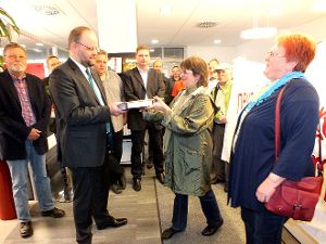 Unter den Augen ihrer Ratskollegen überreicht Elke Rapthel vom ZUG 3014 Unterschriften gegen den neuen Albstädter Wasserpreis an Albstadtwerke-Chef Thomas Linnemann.  Foto: Schwarzwälder-Bote