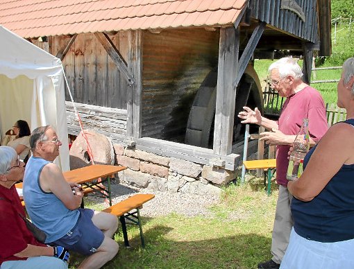 Willi Meder erläutert den Besuchern die Besonderheiten des Mühlrads, das freilich nicht mehr das Original ist, sondern von einer Mühle aus Brigach stammt. Fotos: Kommert Foto: Schwarzwälder-Bote