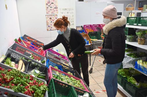 Die ehrenamtliche Mitarbeiterin Pauline Pfeiffer (Mitte) gibt im Tafelladen Gemüse aus. Foto: Schabel