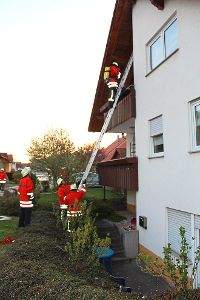 Mit Hilfe einer Steckleiter steigen die Atemschutzträger vom Balkon.   Foto: Wieland Foto: Schwarzwälder-Bote