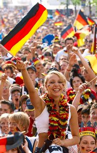 Ein weiblicher Fußballfan winkt auf der Fanmeile am Brandenburger Tor mit einer Deutschland-Fahne. Foto: Kugler Foto: Schwarzwälder-Bote