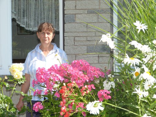 Monika Albert, Vorsitzende der Gartenfreunde, vor dem Vereinsheim, links   die Gaststätte mit der schönen Terrasse von oben.  Foto: Röseler Foto: Schwarzwälder-Bote